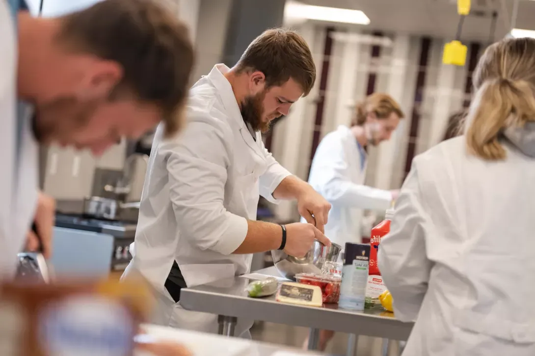 student preparing food in dietetics lab class